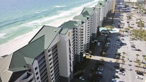 Um hotel à beira-mar com vários edifícios, estacionamento e vista para o oceano.