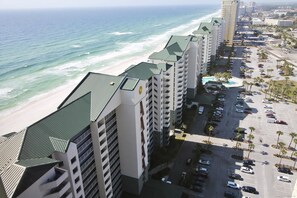 A beachfront hotel with multiple buildings, a parking lot, and a view of the ocean. - Relax in this spacious 3-bedroom beachfront condo in Panama City Beach! (Panama City Beach)