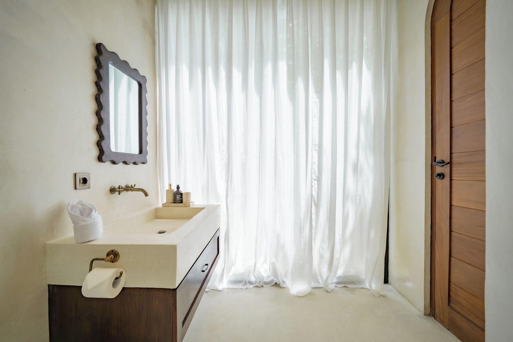 Un bagno con lavandino, specchio e porta in legno.