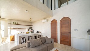 Un salon moderne avec un canapé, une table basse et une cuisine en arrière-plan.
