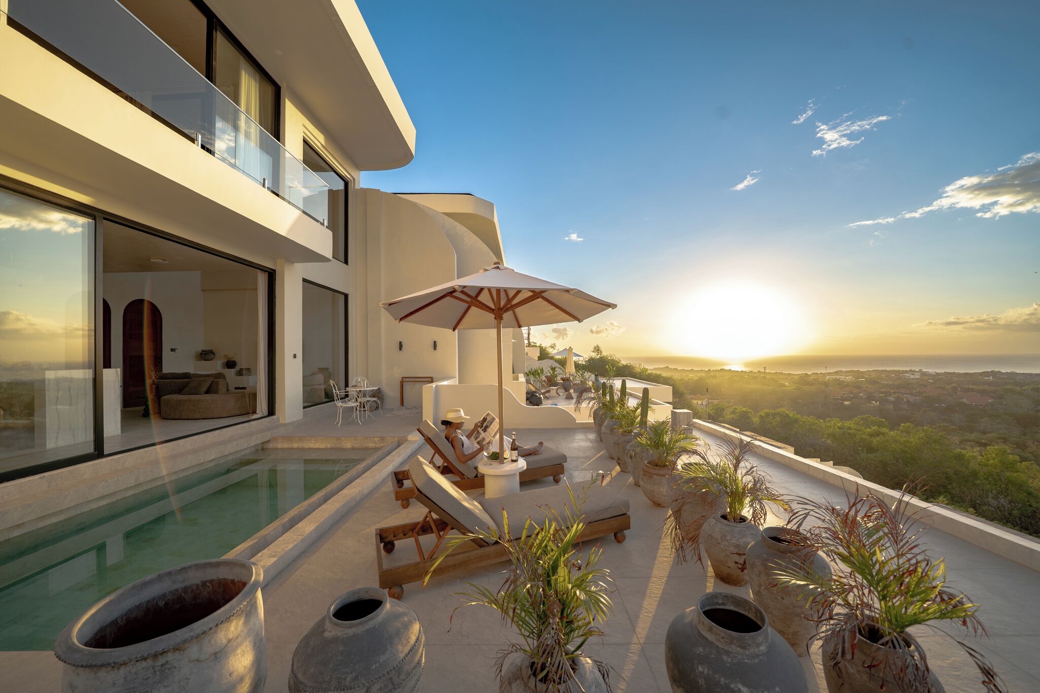 Une maison moderne dotée d’une piscine, d’un espace salon extérieur et offrant une vue sur le paysage.
