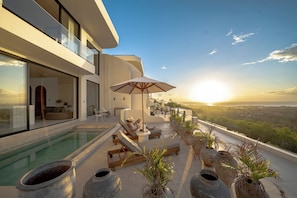 A modern house with a swimming pool, outdoor seating, and a view of the landscape. - Villa Mabu (Uluwatu)