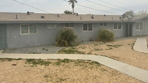 A single-story building with a flat roof, multiple windows, and a satellite dish.