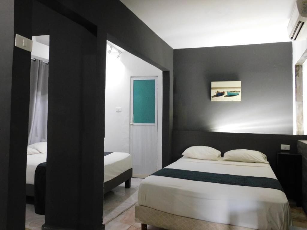 A modern bedroom with a large bed, a bedside table, and a small painting on the wall.
