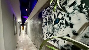 A corridor with a mural of a snow leopard's face on the wall. - zyan Rooms (Villahermosa)