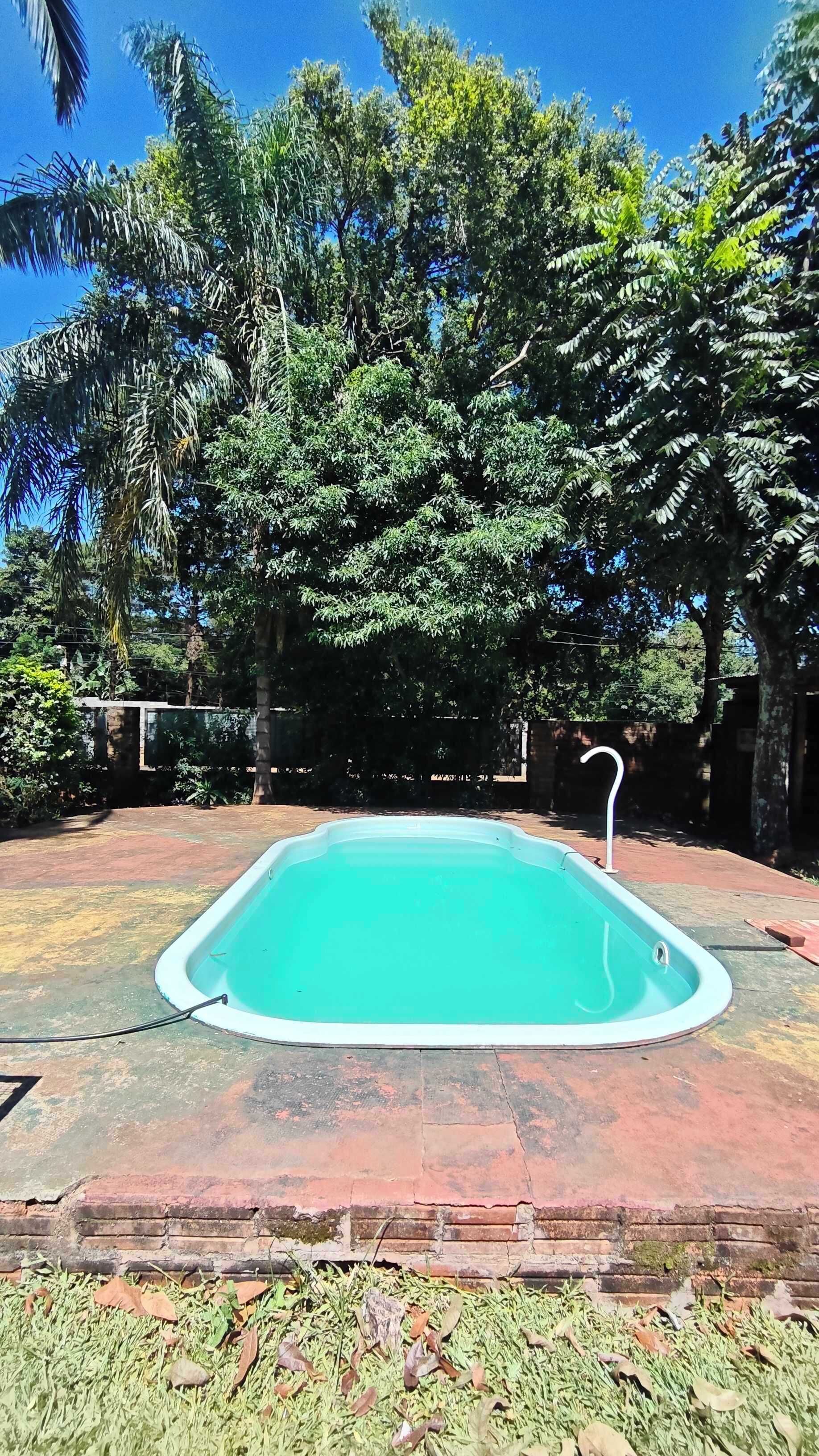 Una piscina rectangular amb un voreja blanca, envoltada d'un paviment de maó.