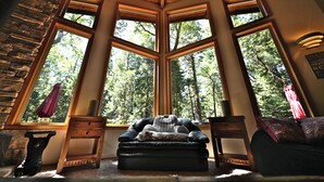 A cozy room with a large window, a fireplace, and a comfortable seating area.