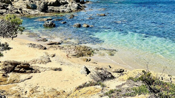 A coastal landscape with rocky terrain, clear blue waters, and distant mountains. - BARCA.Apartment with direct Beach Access (ROSES)