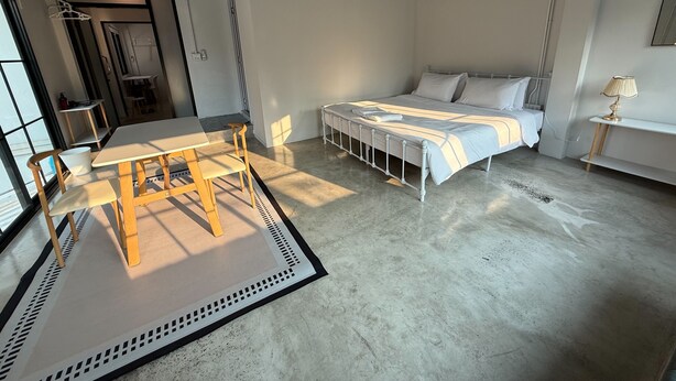 Une chambre moderne comprenant un lit, une table de chevet et un coin repas avec une table et des chaises.
