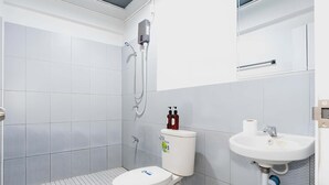 Une salle de bain moderne équipée de toilettes, d’une douche et d’un lavabo.