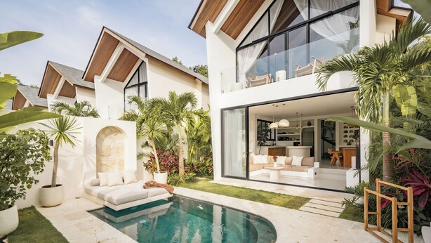 A modern house with a swimming pool, outdoor seating, and lush greenery. - Villa Joann (Uluwatu)