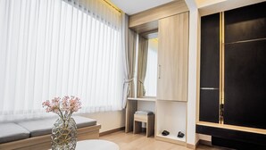 A modern room with a sofa, a small table with a vase, a TV, and a wardrobe. - Orion Villa Telaga Menjer (Garung)