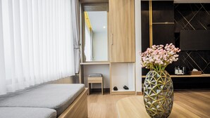 A modern living room with a sofa, a wooden coffee table, a decorative vase with flowers, and a television mounted on the wall. - Orion Villa Telaga Menjer (Garung)
