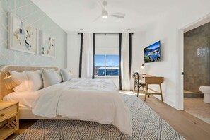 Une chambre à coucher avec un lit, un bureau et une vue sur l’extérieur.