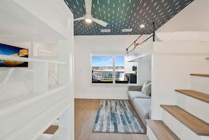 Ein modernes Interieur mit einer Treppe, einer Couch und Blick durch ein Fenster.