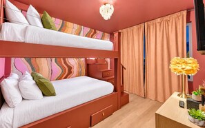 Ein Zimmer mit Etagenbetten, einem Schreibtisch, einer Lampe und einem Fenster mit Vorhängen.