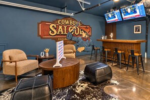 Un espace bar agrémenté d’une enseigne « Cowboy’s Saloon », de sièges en cuir et d’un comptoir.
