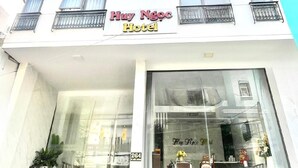 Un edificio de varios pisos con un cartel que dice "Huy Ngoc Hotel".