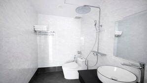 Un baño moderno con inodoro, lavamanos y ducha.