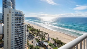 Un hôtel situé en bord de mer, offrant une vue sur l’océan, avec un espace de stationnement et un chemin piétonnier.