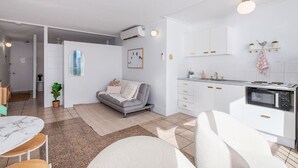 Un appartement moderne comprenant un salon, une cuisine et un coin repas.