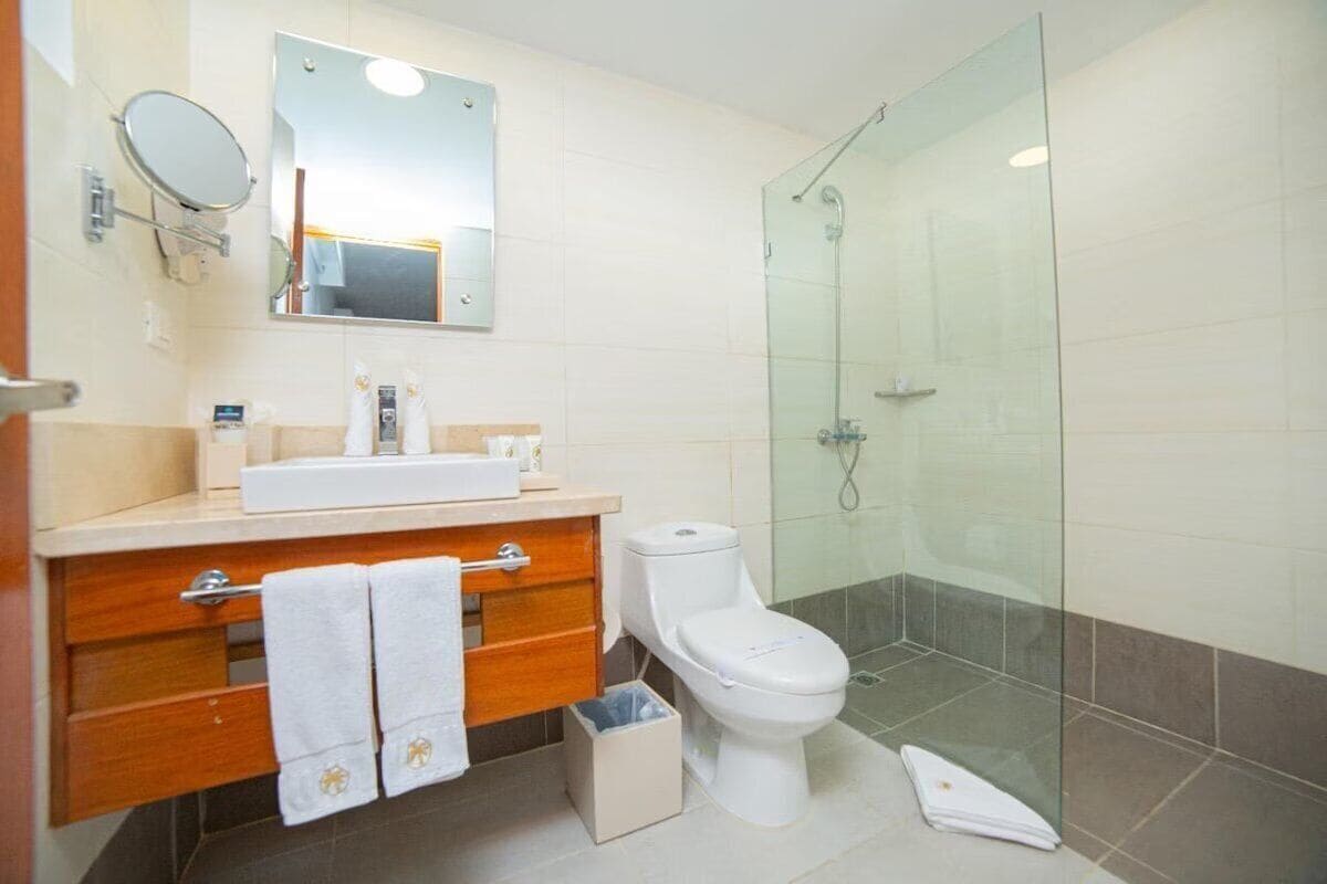 Une salle de bain moderne avec une douche à parois de verre, un lavabo blanc et des toilettes.