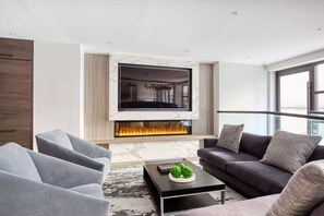 A modern living room with a fireplace, a flat-screen TV, and comfortable seating. - Blueground | Murray Hill, fitness center, nr NYC (New York)