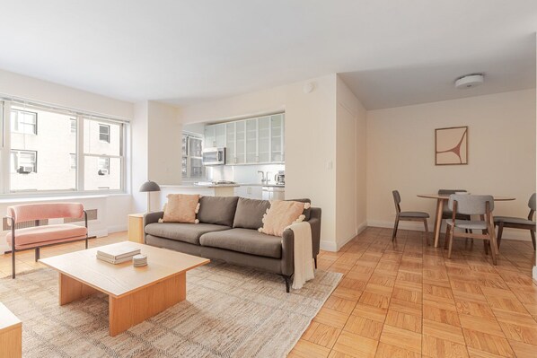 Ein modernes Wohnzimmer mit Sofa, Couchtisch und Essbereich.