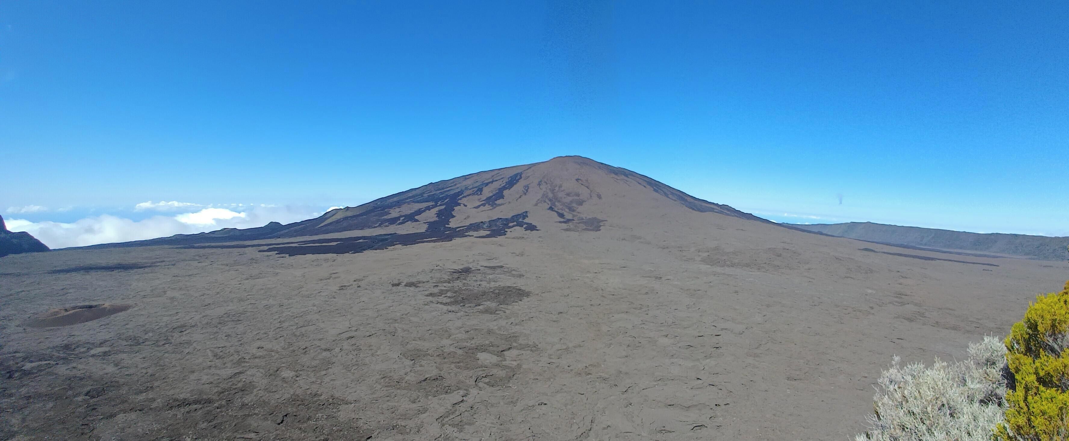 A barren landscape with a prominent mountain in the center.
