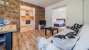A modern living room with a sofa, a TV, and a dining area with a table and chairs. - The Blue House with Sauna & Jacuzzi, Desinić, Croatia (Desinić)