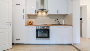 A modern kitchen with white cabinets, a stainless steel oven, and a wooden countertop. - The Blue House with Sauna & Jacuzzi, Desinić, Croatia (Desinić)