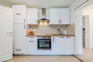 A modern kitchen with white cabinets, a stainless steel oven, and a wooden countertop. - The Blue House with Sauna & Jacuzzi, Desinić, Croatia (Desinić)
