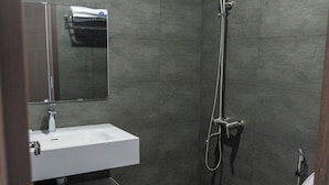 A modern bathroom with a shower, toilet, and sink. - Khánh Vy Hotel (Hue)