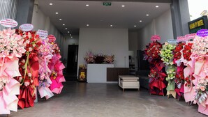 A multi-story hotel with balconies, a reception area, and a flower display. - Khánh Vy Hotel (Hue)