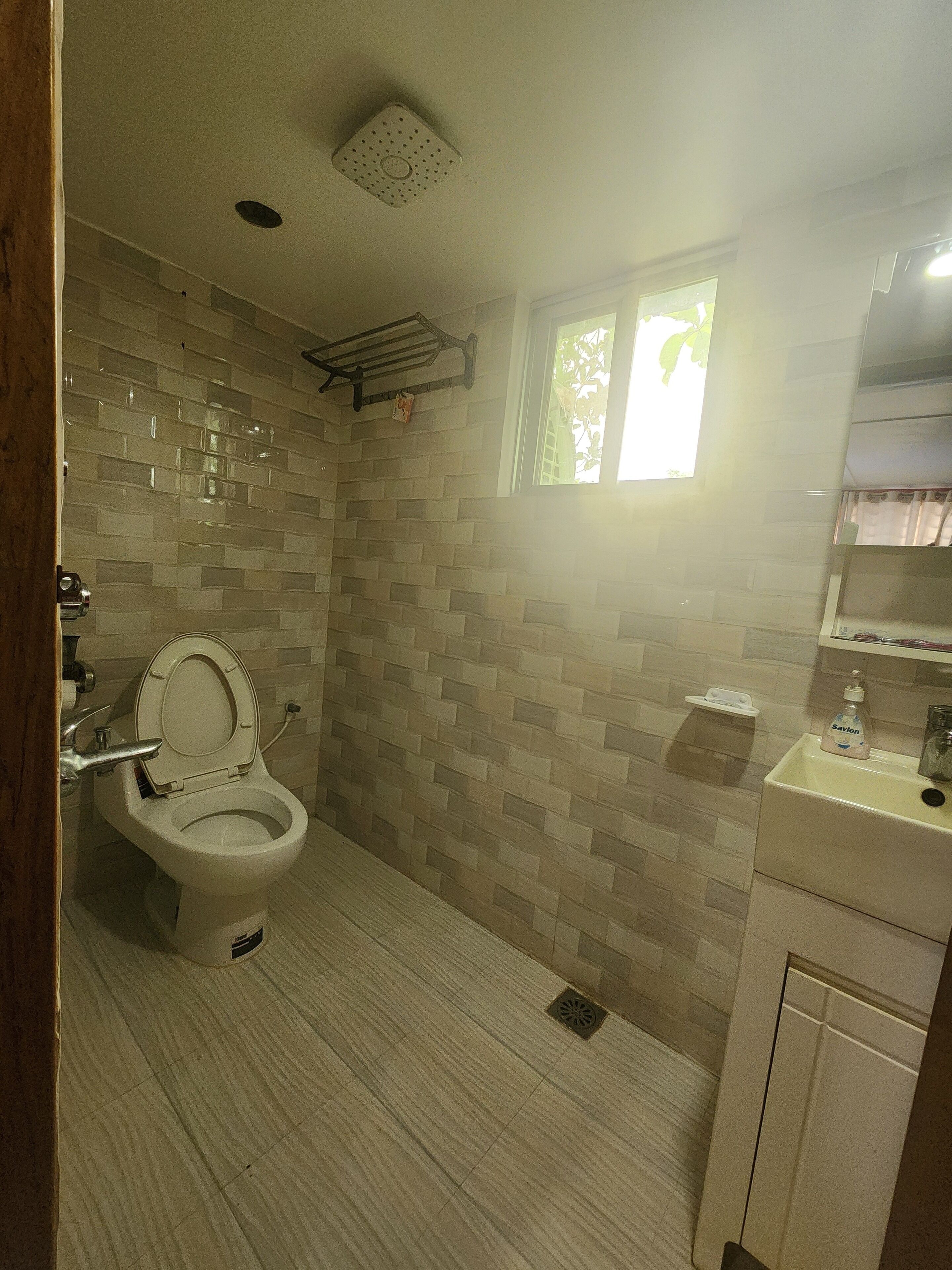 Un baño con inodoro, lavabo y ventana.