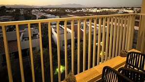Un balcone con vista su una zona residenziale e montagne sullo sfondo.
