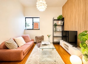 A living room with a sofa, a coffee table, a TV, and a bookshelf. - [Tsubame no Ie Imazato] Luxurious Japanese-Modern Entire House Rental | 3 min to Shin-Fukae | 5 min to Imazato | 12 min to Namba by train | Fully renovated in 2026 | Popular with families with children (Oimazato-minami, Higashinari-ku, Osaka-shi)