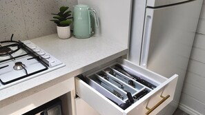 Eine Küche mit Gasherd, Wasserkocher und einem Schubladenorganisator mit Kochgeschirr.