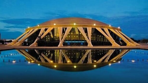 A large, circular building with a reflective pool in front, featuring a unique architectural design with triangular supports. - New, Walk to Beach, Game Room, Fire Pit, King Beds (Norfolk)