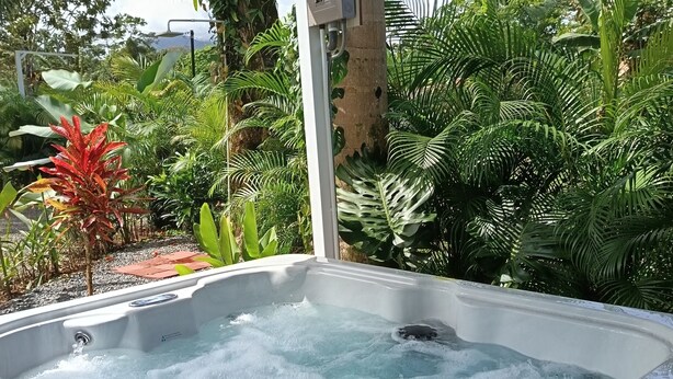 A hot tub with water, surrounded by lush greenery and a pergola structure. - Villa Mali Arenal La Fortuna La Fortuna Costa Rica Jacuzzi Area (Provincia de Alajuela)