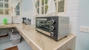 A kitchen with a built-in toaster oven, a sink, and a window with curtains. - Villa Mali Arenal La Fortuna La Fortuna Costa Rica Jacuzzi Area (Provincia de Alajuela)