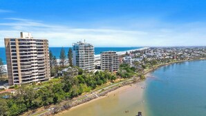Un paysage urbain côtier avec de hauts immeubles, une plage et un port de plaisance.