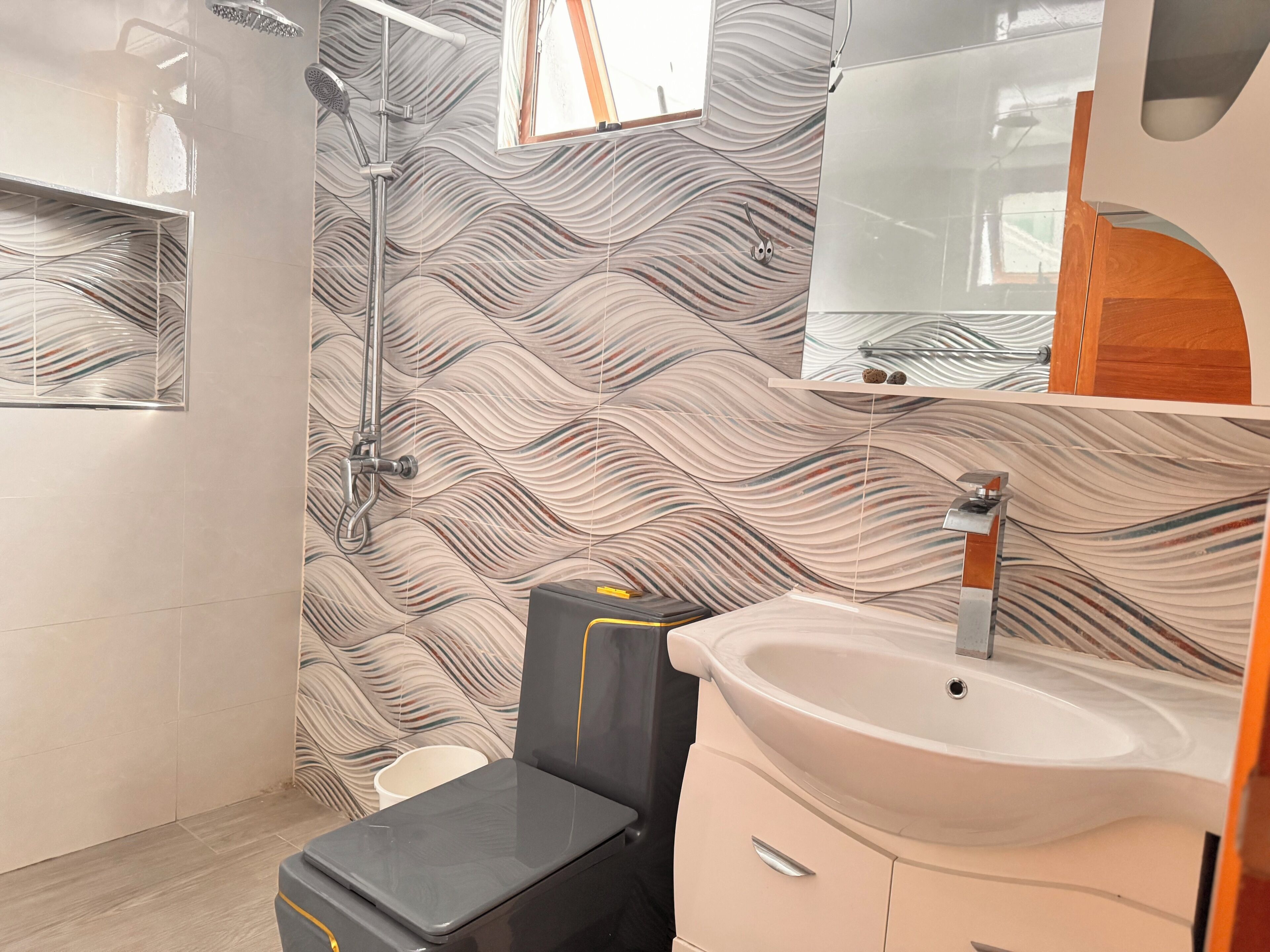 Un baño con ducha, lavamanos y espejo.