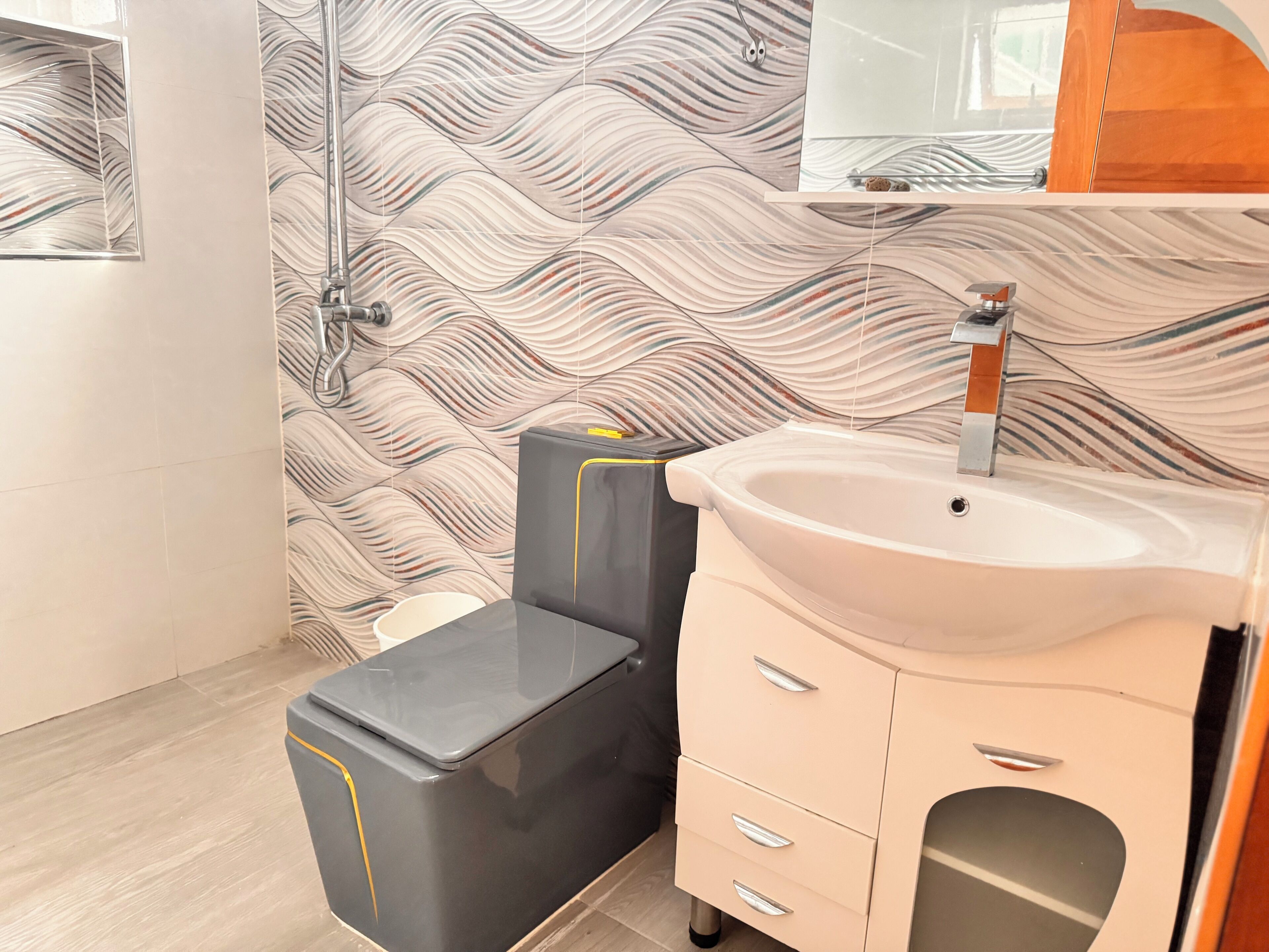 A bathroom with a modern design, featuring a black and beige sauna, a white sink, and a mirror above it.