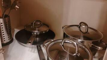A kitchen with stainless steel pots and pans on a countertop.
