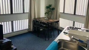 Une cuisine compacte comprenant un coin repas, un évier et une petite plante.