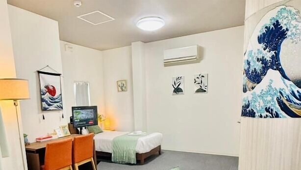 Une chambre d’hôtel avec deux lits, un bureau et une chaise.