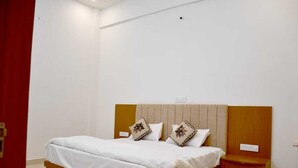 Una camera da letto con un letto di legno, due cuscini, un comodino e una porta rossa.