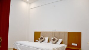 Una camera da letto con un letto, due cuscini, un comodino e una parete rossa a contrasto.