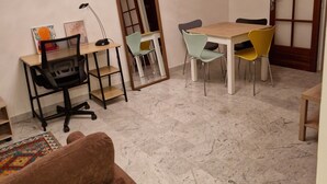A room with a desk, two chairs, a sofa, a mirror, and a door with frosted glass panels. - city-centre apartment close to historic sites and shops (Nîmes)